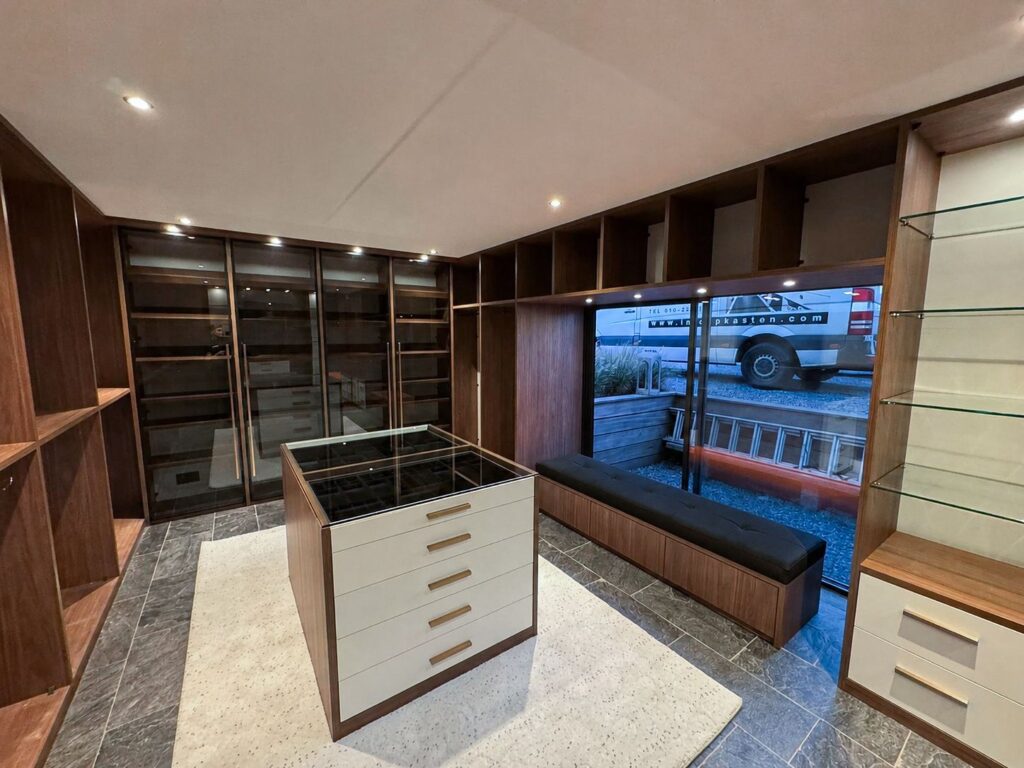 Ruime Amerikaanse inloopkast met maatwerk opbergkasten, kledingroedes en modern interieur