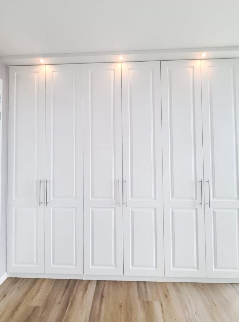 Maatwerk inloopkast met klassieke kastdeuren en tijdloos interieurdesign.