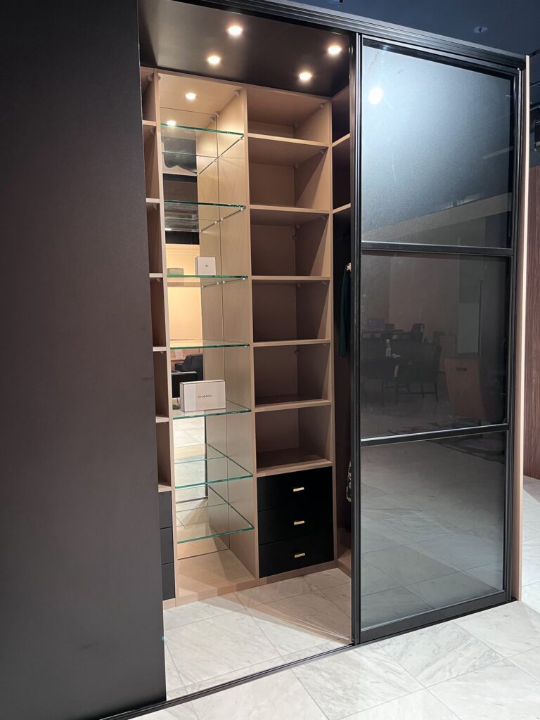 Inloopkasten showroom met diverse maatwerk walk-in closets en sfeervolle verlichting.